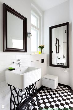 a black and white checkered floor in a bathroom with two mirrors on the wall