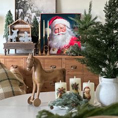 a christmas scene with santa clause on the wall and candles in front of it, next to a horse figurine