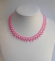 a pink beaded necklace on a white mannequin