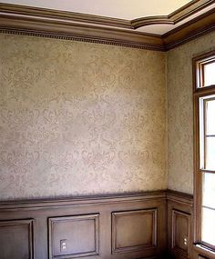 an empty room with wooden floors and wallpaper