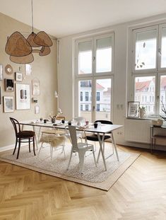 a dining room table with chairs and pictures on the wall in front of it,