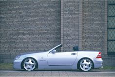 a silver car parked in front of a brick building