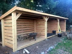 a large wooden shed sitting in the middle of a yard next to a fire pit