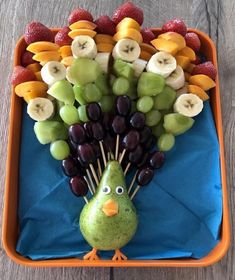 a tray filled with grapes, apples, kiwis and other fruit on sticks