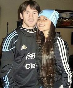 a young man and woman are posing for a photo in front of a tv screen