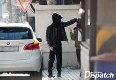 a man standing next to a white car on a city street