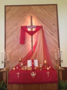 the altar is decorated with candles and red cloth