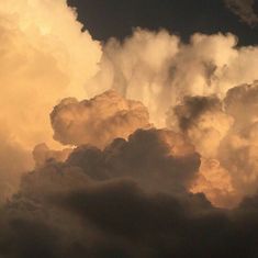 the sky is filled with lots of white clouds and some dark brown clouds are in the distance