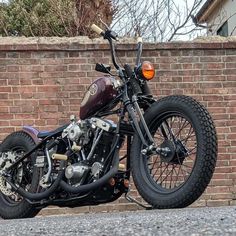 a motorcycle parked next to a brick wall