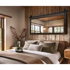 a bed sitting under a mirror in a bedroom