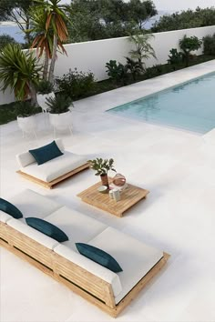 an outdoor lounge area next to a swimming pool