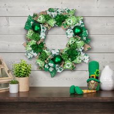 a st patrick's day wreath on a mantle with potted plants and decorations