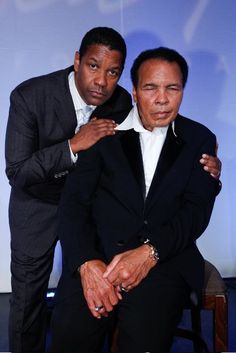 two men in suits posing for the camera