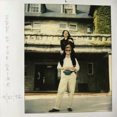 a man and woman standing in front of a building with a child on his shoulders