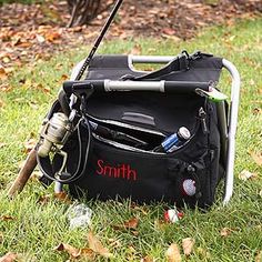 a black bag with fishing gear on it sitting in the grass