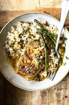 a white plate topped with rice and asparagus