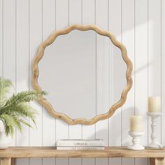 a wooden table topped with a mirror next to a potted plant and two candles