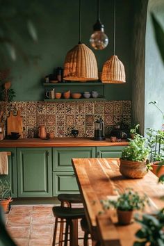 a kitchen with green walls and wooden table in the center, hanging lights above it