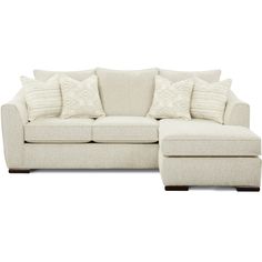 a white couch and ottoman with pillows on it