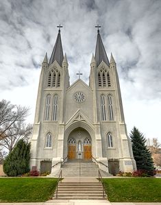 a large church with two steeples on it's sides and stairs leading up to the front door