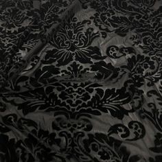 a black and white photo of an intricately designed bed sheet with the sheets pulled down