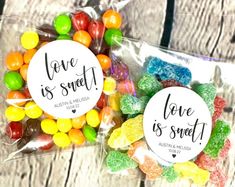 two bags filled with candy sitting on top of a wooden table next to each other