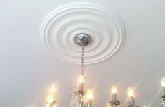 a chandelier hanging from the ceiling in a room with white walls and ceilings