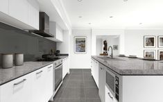 a kitchen with white cabinets and gray counter tops