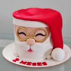 a close up of a cake on a plate with santa claus's hat and glasses