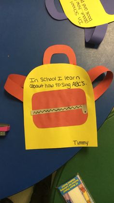 a paper bag that has been cut out to look like a schoolbag with writing on it