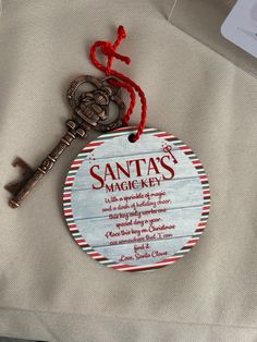 a key hanging from the side of a wooden sign that says santa's magic key