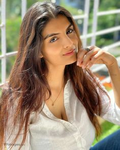 a beautiful young woman sitting on top of a couch