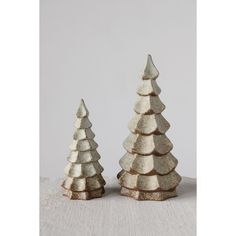 two small silver trees sitting on top of a table