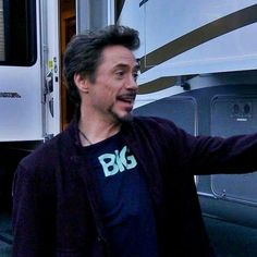 a man standing in front of an rv with his arms out and pointing at something