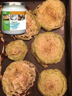 some artichokes are sitting on a baking pan with a can of food in the middle