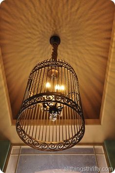 a bird cage hanging from the ceiling in a room