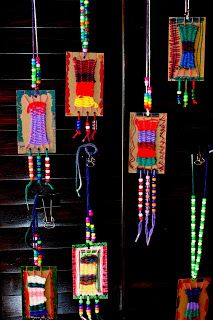 several colorful beads hanging from the ceiling in a room with black walls and wooden steps