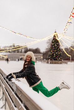 a woman leaning on a fence in the snow