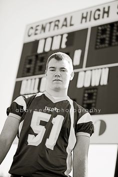 a football player is standing in front of the scoreboard with his hands on his hips