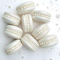 some white pearls are arranged on top of each other in the shape of macaroons