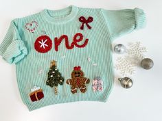 a green sweater with christmas decorations and ornaments around it