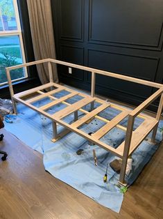 an unfinished bed frame in the middle of being installed on top of a hard wood floor