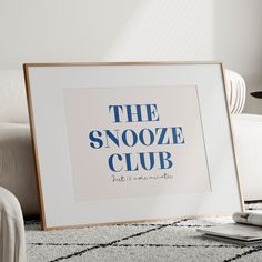 the snooze club sign is displayed in front of a white couch and chair