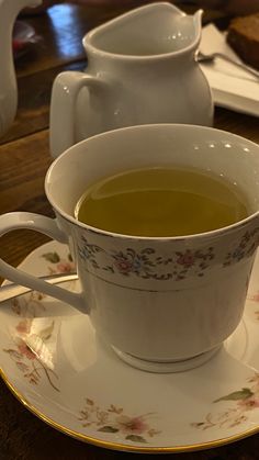 a cup of green tea sitting on top of a saucer next to a plate