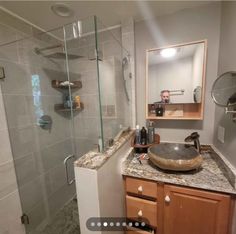 a bathroom with a sink, mirror and shower stall is shown in this image from the inside