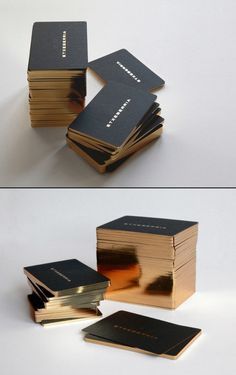 several stacks of black and gold books stacked on top of each other