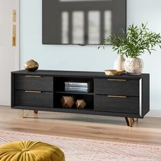 a black entertainment center with gold accents in a living room