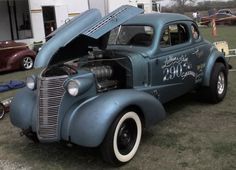 an old blue car with the hood open