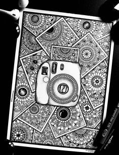 a drawing of a camera on top of a piece of paper next to some pens