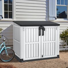 a blue bicycle parked next to a white storage shed